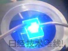   發(fā)光試驗中的LED元件。基板尺寸：1cm見方，元件尺寸：0.3mm見方，注入電流：約200mA，中心波長：450nm 